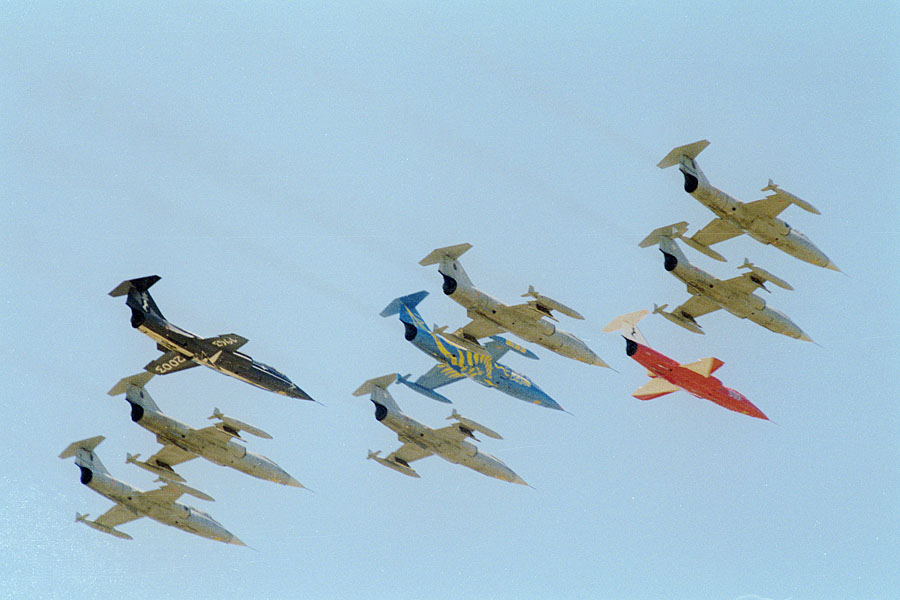 [it] Pratica di Mare 2004: insieme a 6 starfighter in colorazione standard hanno volato per l'ultima volta gli "special color" del 9 e del 20 gruppo (4 stormo, 1 e 2 da sinistra)  e del 9 stormo      Fotocamera:  Canon AV-1 |  Obiettivo:  Soligor G/S 200/2.8 |  Film:  Perutz 100  [en] Last italian Starfighters flight: note 3 special color from 4th wing (left and middle) and 9th wing (red one)      Camera:  Canon AV-1 |  Lens:  Soligor G/S 200/2.8 |  Film:  Perutz 100 